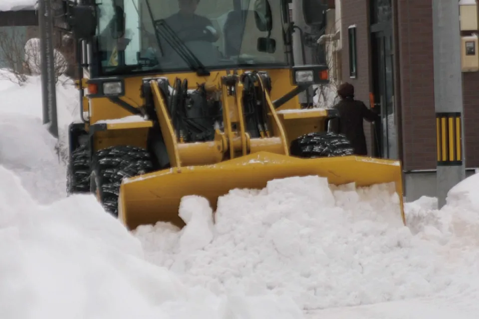 一般住宅玄関前、ショベルカーによる排雪作業の様子